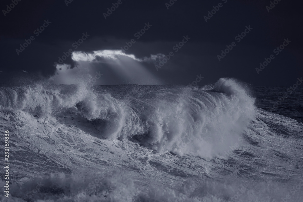 Stormy waves against dark sky at sunset