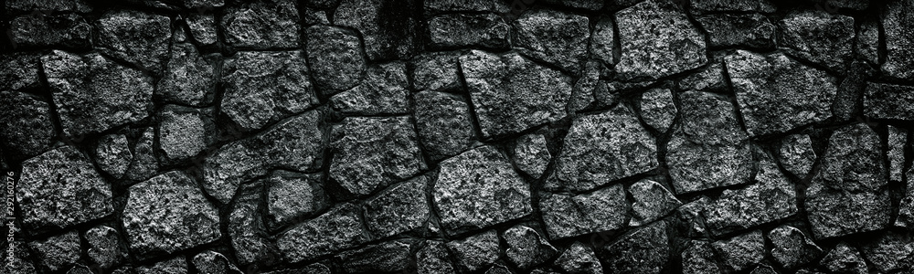 Natural granite stone wall wide texture. Dark rock masonry widescreen gloomy gothic background - obrazy, fototapety, plakaty 