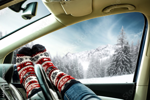 Winter car interior and woman legs with christmas socks. Free space for your decoration 