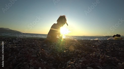 4K Child operates with knife sitting against the declining sun