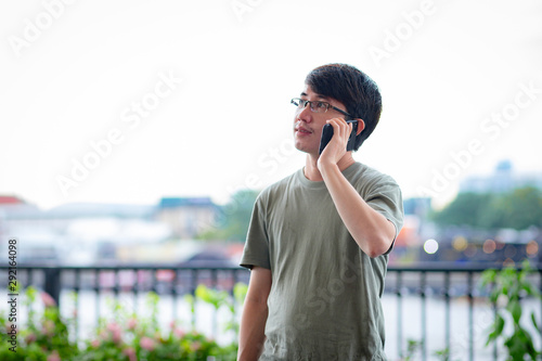 Man calling phone on the riverside view point © AlivePhoto