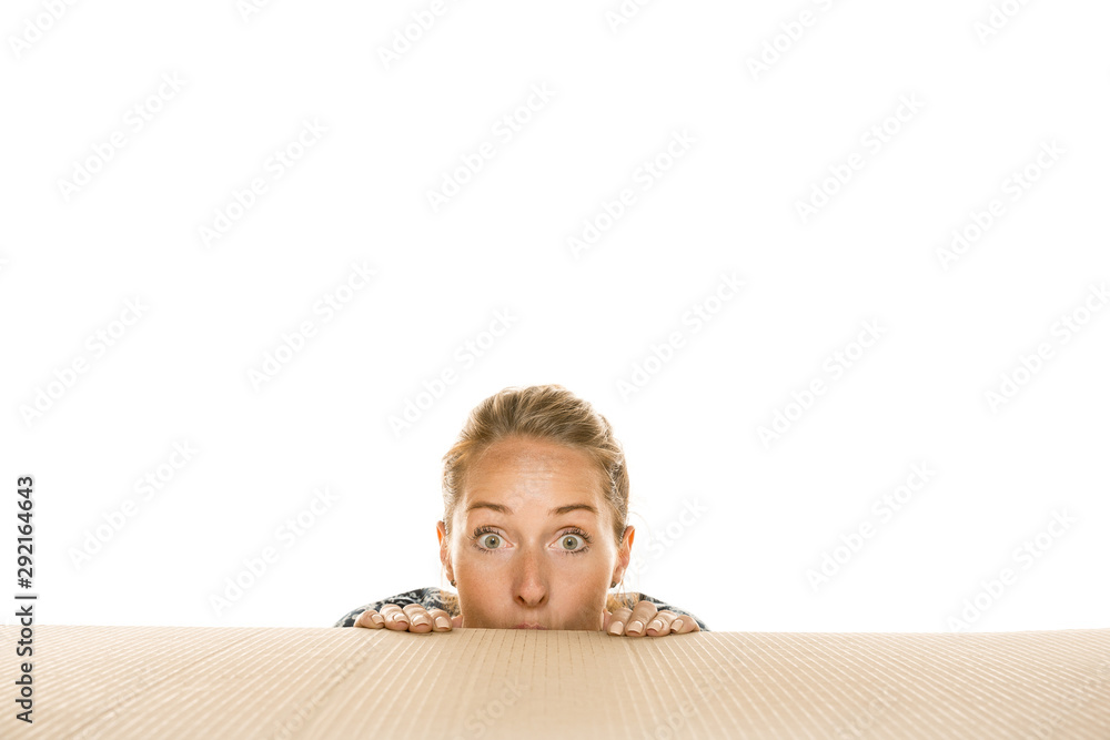Young astonished woman opening the biggest postal package isolated on white. Shocked female model on top of cardboard box looking inside. Gift, present, delivery, shipment, sales, black friday concept Young astonished woman opening the biggest postal package isolated on white. Shocked female model on top of cardboard box looking inside. Gift, present, delivery, shipment, sales, black friday concept