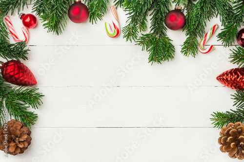 Christmas new Years background in retro vintage style with fresh fluffy fir tree branches red ornament balls candy canes on white plank wood. Greeting card poster banner template with copy space