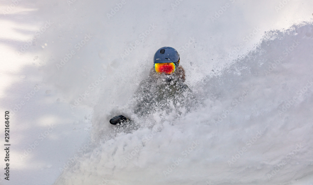 female snowboarder curved and brakes spraying loose deep snow on the freeride slope. downhill with snowboards in fresh snow. freeride world champion. female snowboarder curved and brakes spraying loose deep snow on the freeride slope. downhill with snowboards in fresh snow. freeride world champion.