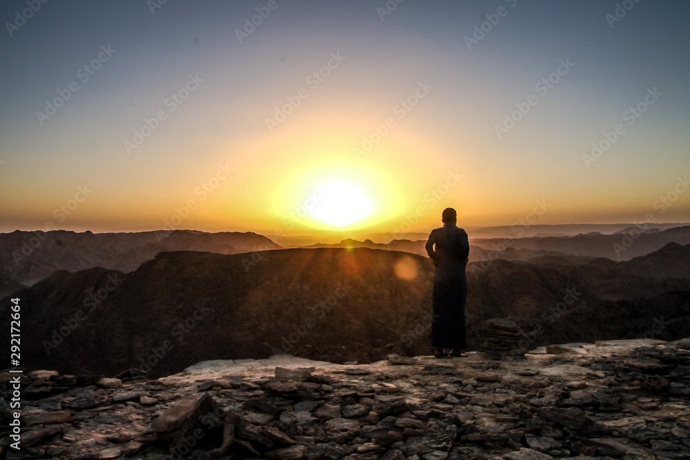 monk standing on a hill at the sunset
