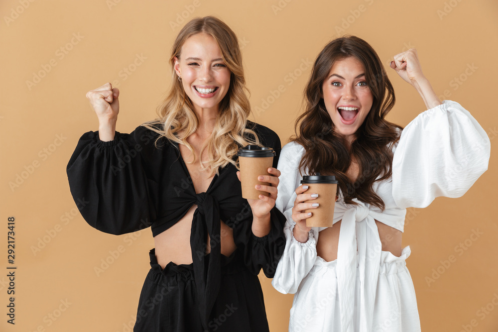 Portrait of excited women showing winner gesture while drinking coffee Portrait of excited women showing winner gesture while drinking coffee