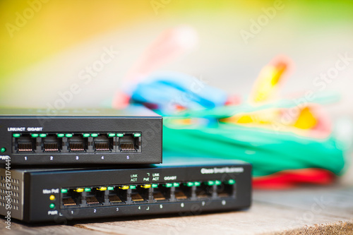 Home office concept.  Black and silver cloud switches interconnected using bright cables on the wooden background. Smart home equipment. Space for your text. Closeup. photo