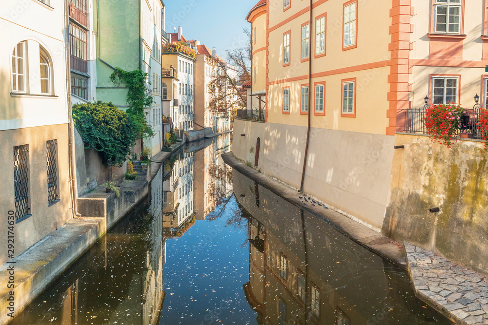 River between old houses with flowers with reflection in autumn
