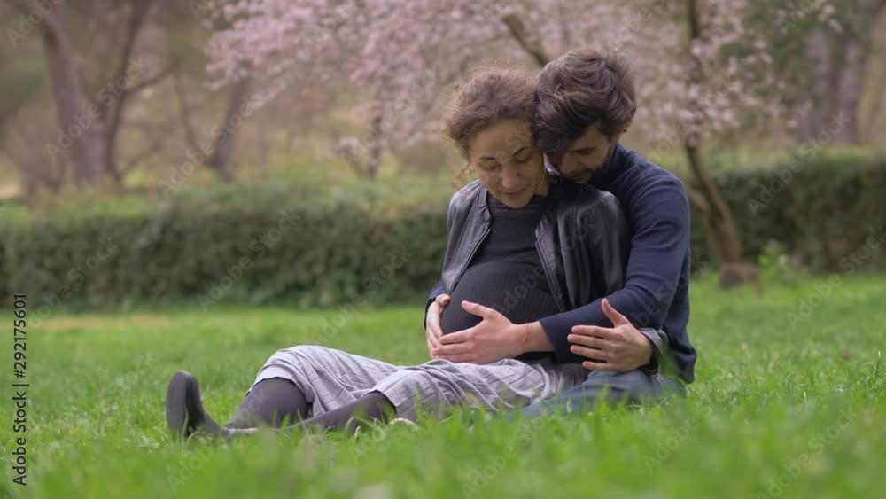 Pregnancy,joy,birth.Pregnant young lovers cuddling in the park Pregnancy,joy,birth.Pregnant young lovers cuddling in the park