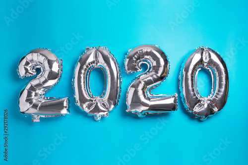 Metallic 2020 New Year balloons isolated on blue.