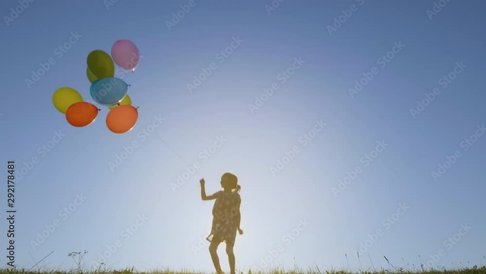 Slow motion shot of a little girl jumping and playing with balloons Slow motion shot of a little girl jumping and playing with balloons