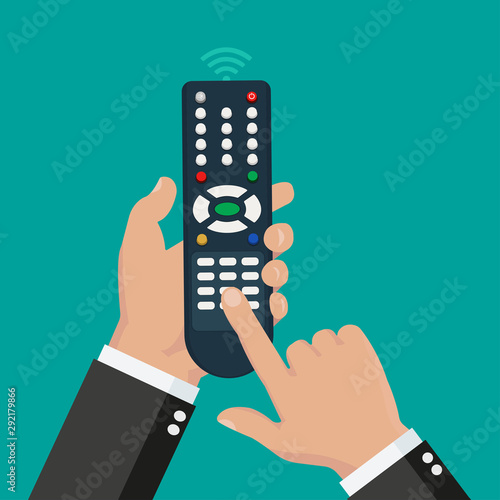 Hand holding wireless remote with finger pushing the button