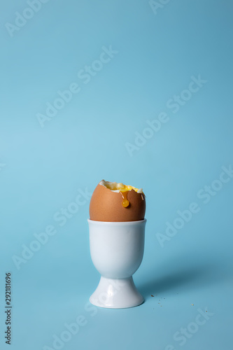Vászonkép Soft boiled egg in egg cup on blue background