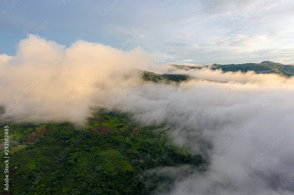 Aerial top view of the moving flow of the mist or foggy in between the hills of mountains
