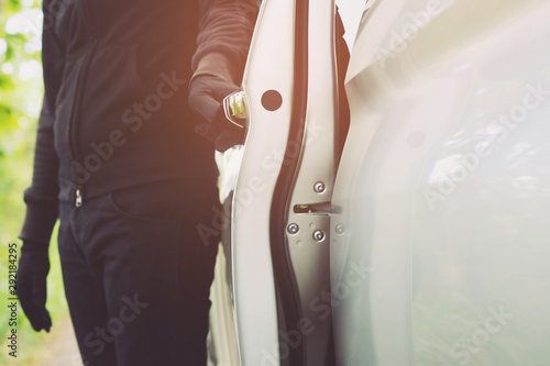 Foto Close up hand pulling the handle of a car thief  wearing black clothes and glove stealing automobile trying door handle to see if vehicle is unlocked  trying to break into
