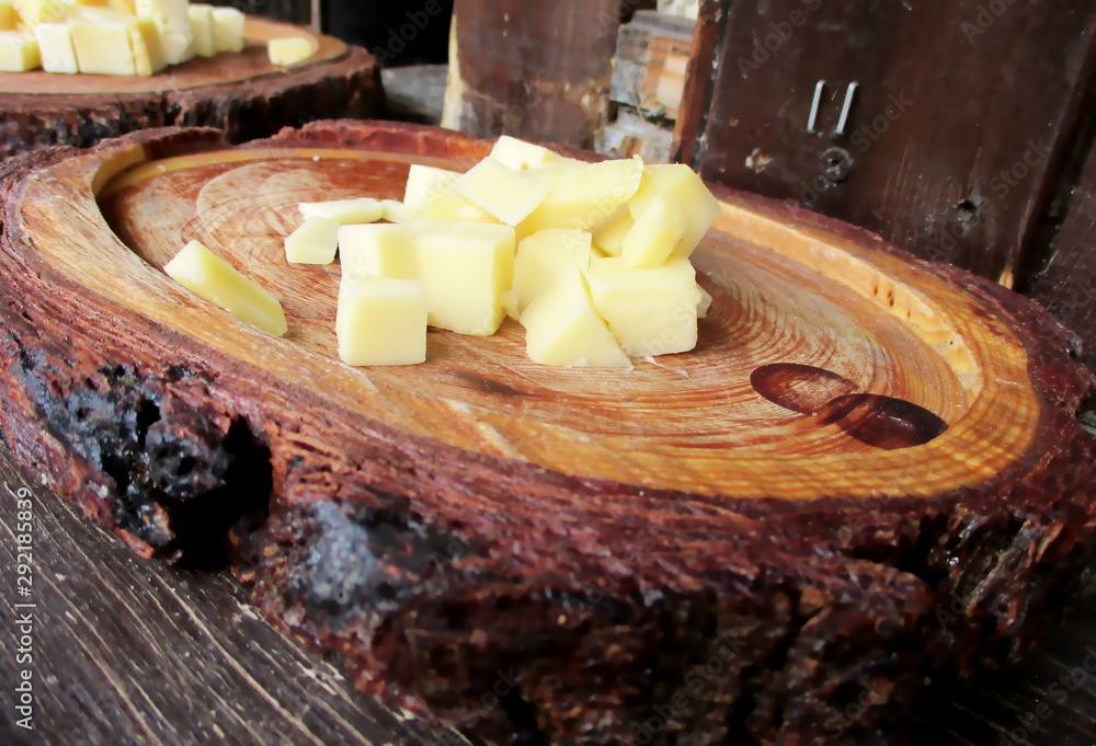 Foto de Cubes de fromage à pâte ferme disposés sur un plateau rustique ...