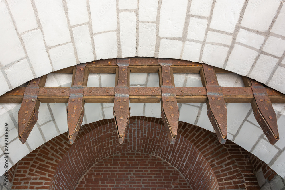 Obraz premium An ancient gateway made of stonework, wood and metal. Rusty and weathered.