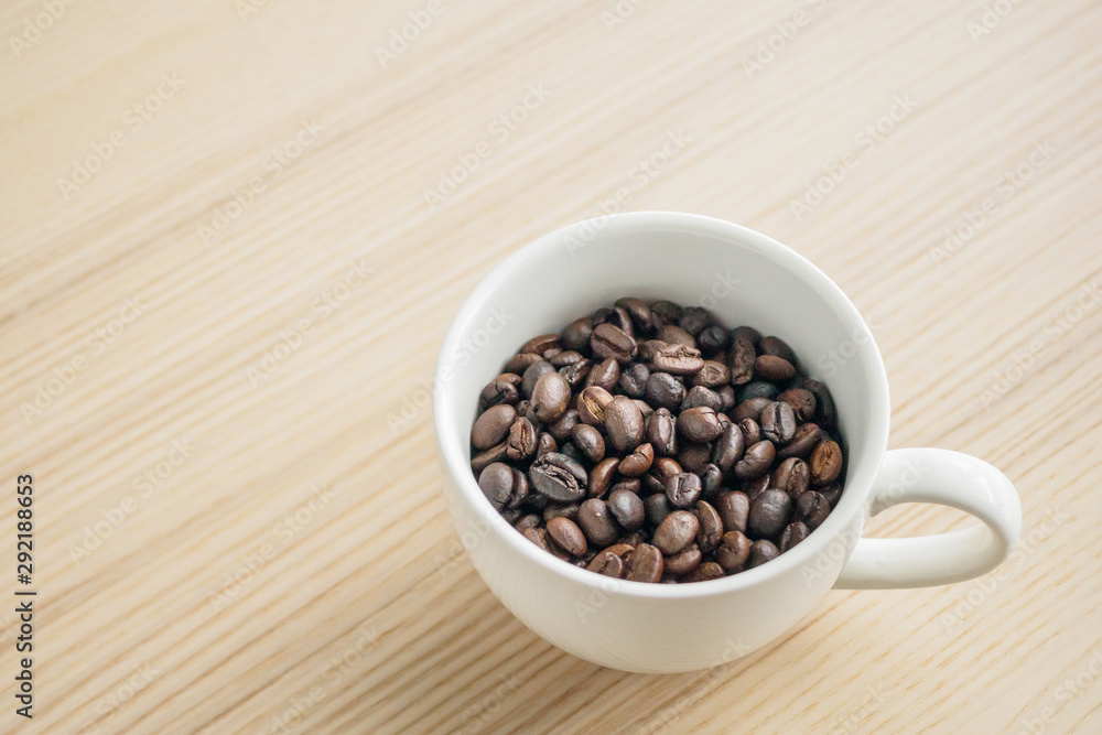 fresh roasted coffee beans in white cup on wood table fresh roasted coffee beans in white cup on wood table