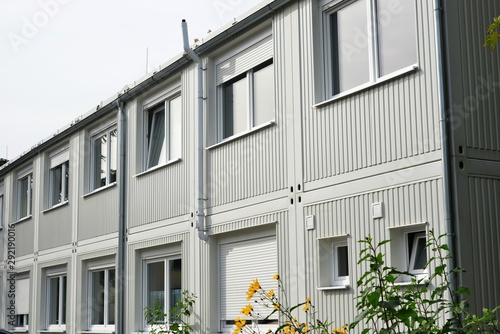 Mehrere miteinander verbundene Bürocontainer-Raummodule nebeneinander und übereinander als provisorisches Bürogebäude mit Parkplatz