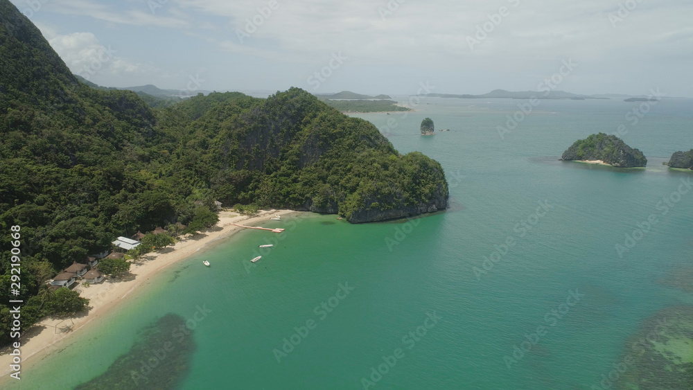 Aerial view islands with sand beach and turquoise water in blue lagoon among coral reefs, Caramoan Islands, Philippines. Landscape with sea, tropical beach.