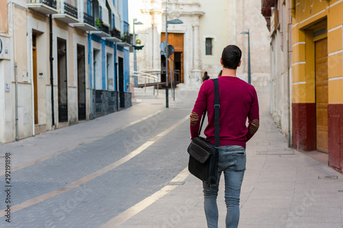 Young businessman is walking on the street with his backpack