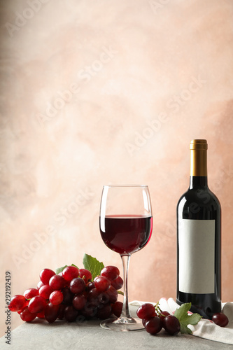 Grape, bottle and glass with wine on grey background, space for text