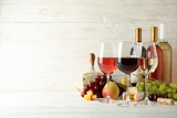 Fruits, cheese, bottles and glasses with different wine on white background, space for text