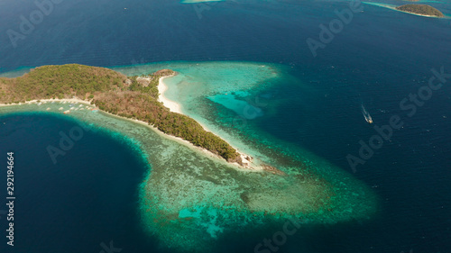 Aerial drone Island in blue lagoon with sandy beach and coral reef. Malcapuya, Philippines, Palawan. Tropical landscape with blue lagoon, coral reef