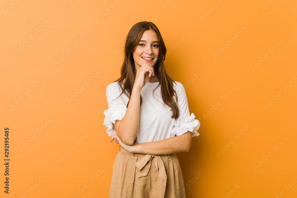 Young caucasian woman smiling happy and confident, touching chin with hand. Young caucasian woman smiling happy and confident, touching chin with hand.