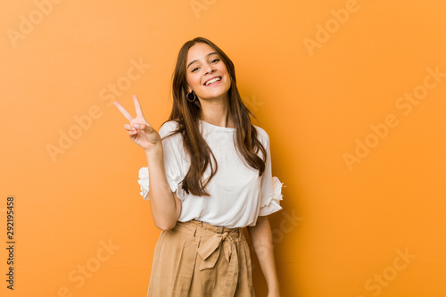 Fotografía Young caucasian woman joyful and carefree showing a peace symbol with fingers