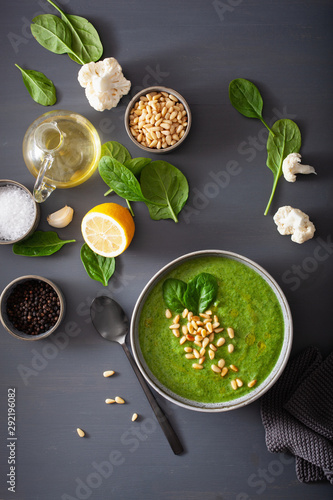 green creamy cauliflower spinach soup on gray background