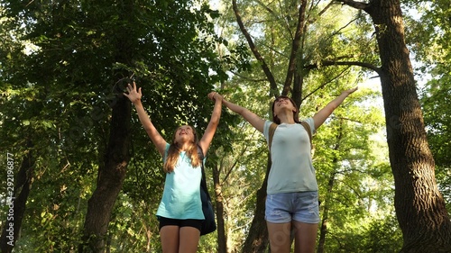 teamwork tourists teenagers. happy girls travelers go with backpacks in forest. Hiker woman walks in the forest. happy hiker girl in summer park. teenager girl adventures on vacation. © zoteva87