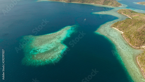 aerial view tropical islands with blue lagoon, coral reef and sandy beach. Palawan, Philippines. Islands of the Malayan archipelago with turquoise lagoons.