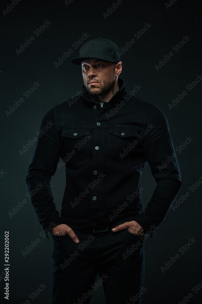 Strong and fit man bodybuilder in black shirt and hat. Sporty muscular guy athlete. Sport and fitness concept. Men's fashion. Strong and fit man bodybuilder in black shirt and hat. Sporty muscular guy athlete. Sport and fitness concept. Men's fashion.