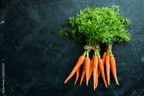 Photographie Fresh carrots on a black stone background