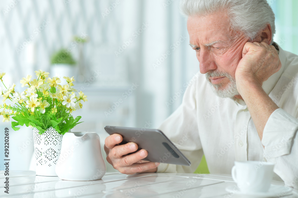 Portrait of thoughtful senior man using tablet Portrait of thoughtful senior man using tablet
