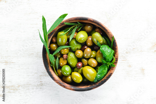 Olives in a bowl, olive oil, spices and herbs. Top view. Free space for your text. © Yaruniv-Studio