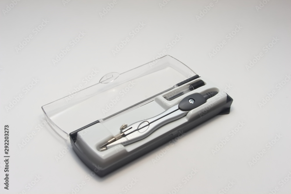 Compass with interchangeable in a box with stylus on a white background Compass with interchangeable in a box with stylus on a white background