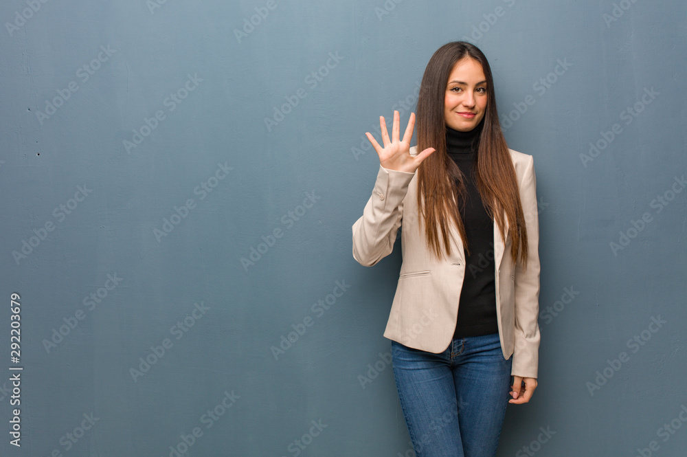Young business woman showing number five Young business woman showing number five