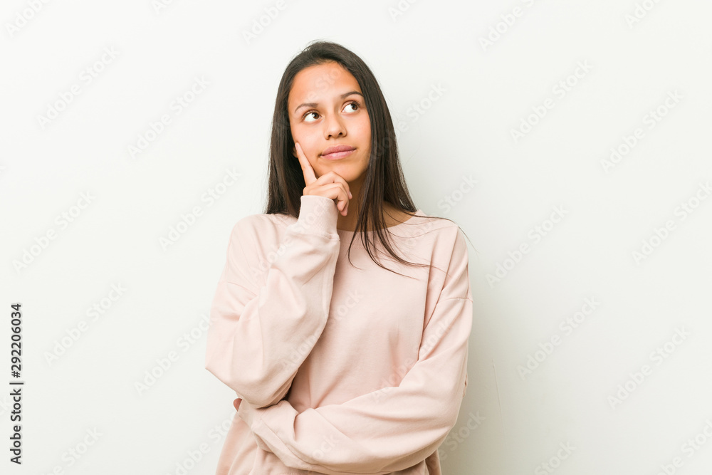 Young cute hispanic teenager woman looking sideways with doubtful and skeptical expression. Young cute hispanic teenager woman looking sideways with doubtful and skeptical expression.