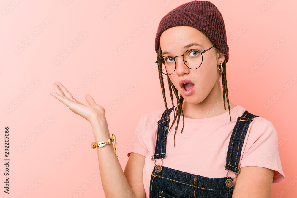 Young caucasian hipster woman impressed holding copy space on palm. Young caucasian hipster woman impressed holding copy space on palm.