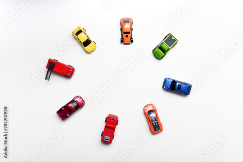 Overhead shot of child's toy cars arranged on a white table, no people in shot photo