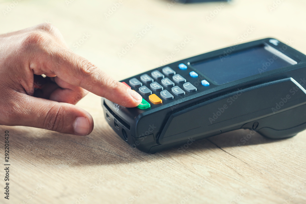 man hand payment terminal on desk