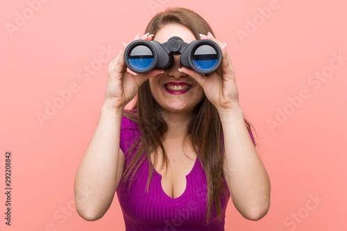 Young caucasian woman looking through binoculars