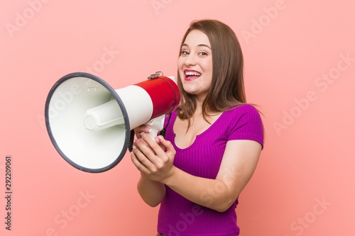 Young caucasian woman speaking through a megaphone