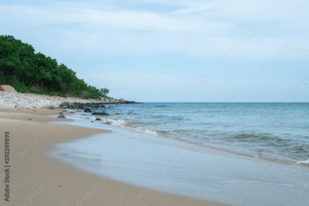 Beautiful waves rolling up on a sandy beach. Summertime in Österlen, Sweden. Beautiful waves rolling up on a sandy beach. Summertime in Österlen, Sweden.