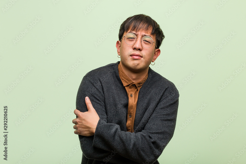 Young chinese man against a green wall Young chinese man against a green wall