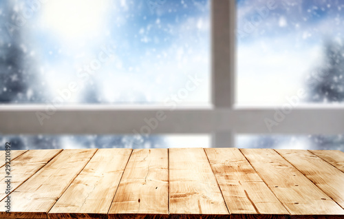 Wooden desk space and winter background of window and snow 
