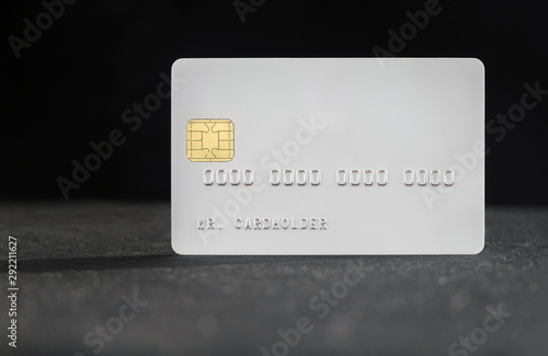 White blank bank credit card on dark background with shalow depth of field photo