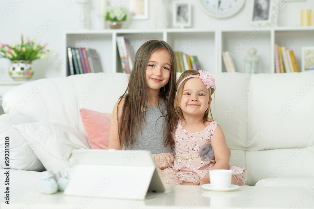 two cute little girls sitting on sofa two cute little girls sitting on sofa